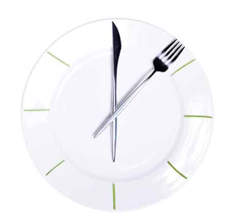 Clock made of knife and fork, isolated on white background