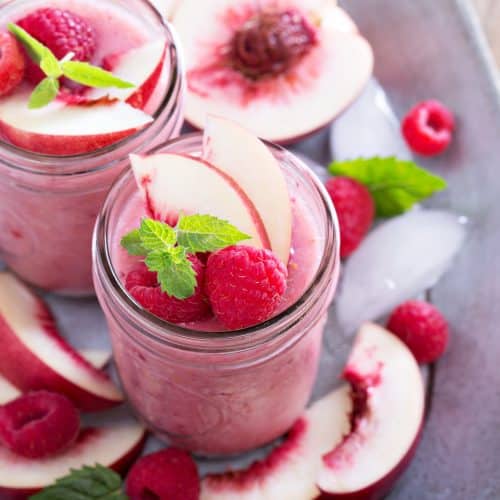 Raspberry and white peach smoothie in mason jars