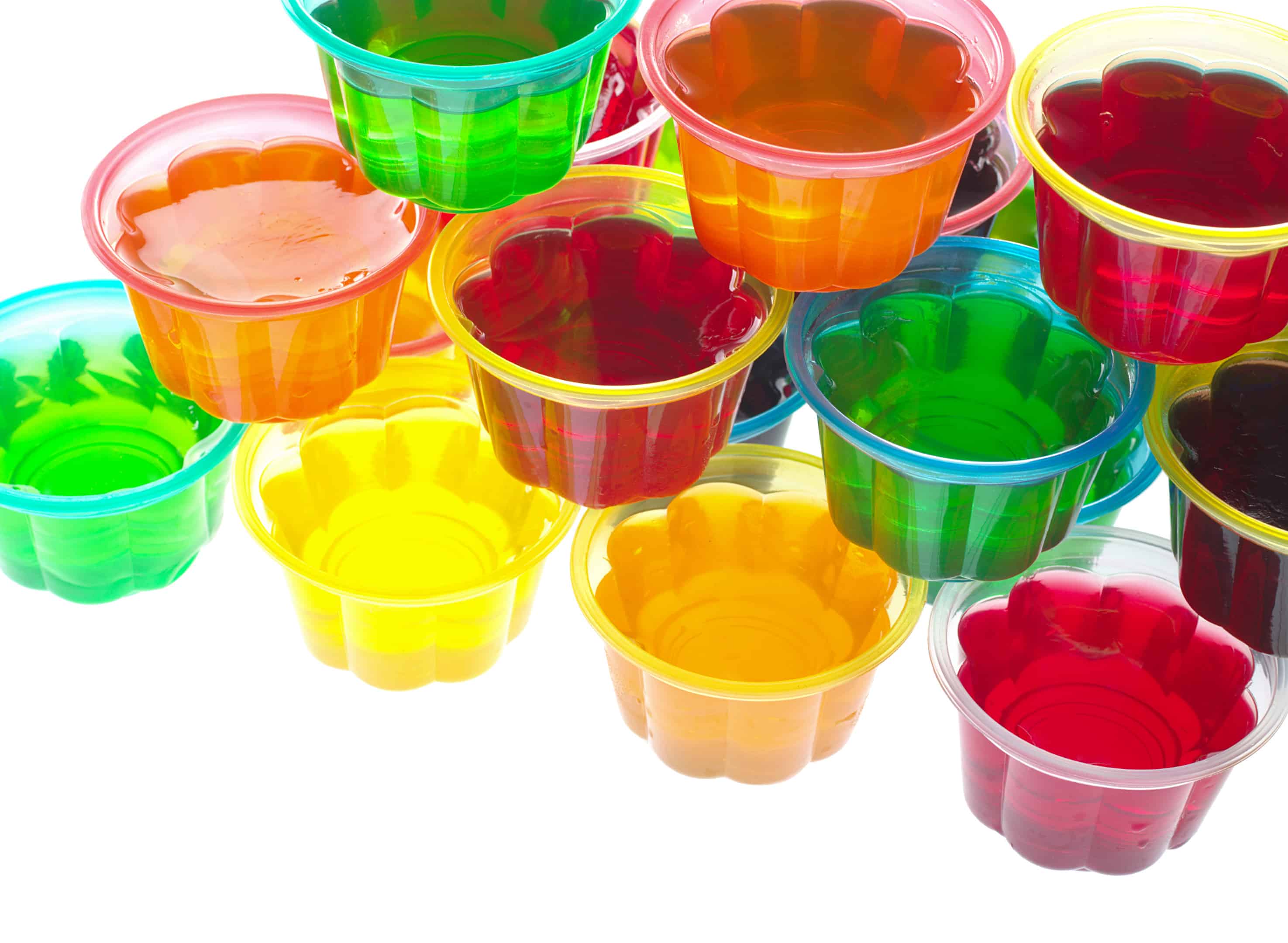 Colorful jellies in plastic bowls arranged in a pile and photographed from above