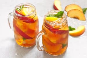 Mason jars of peach tea with ice