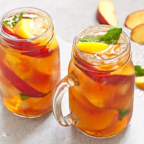 Mason jars of peach tea with ice
