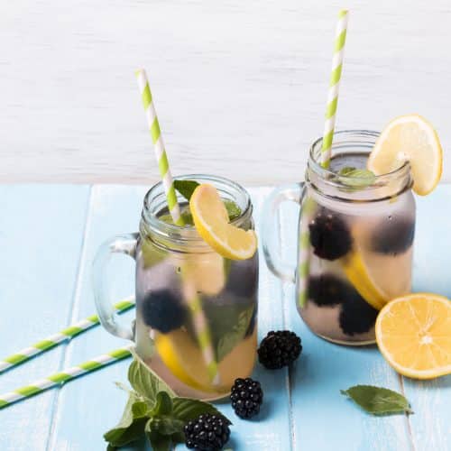 Detox water with blackberry and lemon in glass jars